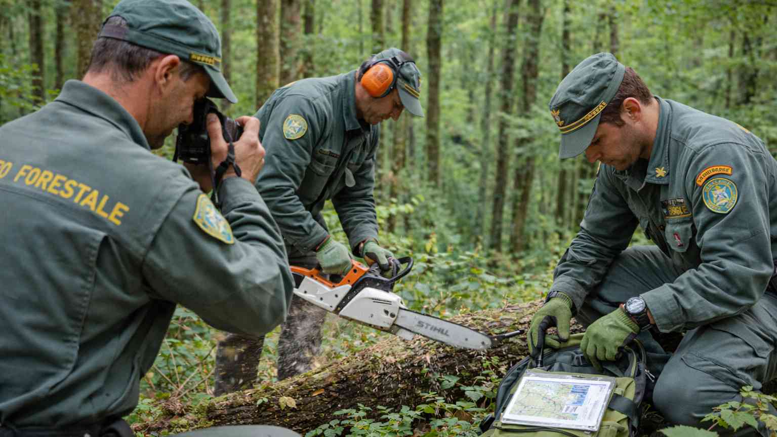 Operatori del Corpo Forestale e di Vigilanza Ambientale impegnati in attività di sorveglianza e prevenzione incendi nel bosco, fotografia professionale, 1200 px orizzontale.